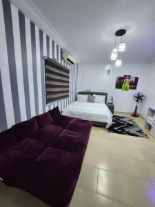 a living room with a couch and a bed at Asfranz Apartment Luxury One-Bedroom with Private Garden in Abuja