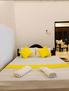 ein Schlafzimmer mit einem großen Bett mit gelben Kissen in der Unterkunft Leyon-Tourist Inn in Negombo