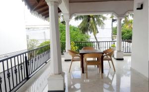 eine Veranda mit einem Tisch und Stühlen auf dem Balkon in der Unterkunft Leyon-Tourist Inn in Negombo