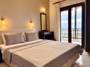 a bedroom with a large bed and a balcony at Panorama Dream studios A in Vourvourou
