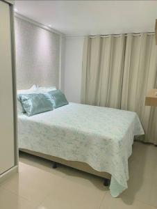 Un dormitorio con una cama con almohadas azules. en Apê da tia Adei, en Parnamirim