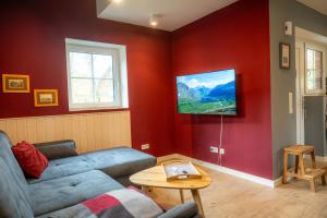 uma sala de estar com um sofá e uma televisão na parede em Ferienhaus Luv em Pellworm