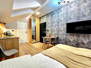 1 dormitorio con 1 cama y 1 mesa con sillas en Apartamenty na 102 en Iława