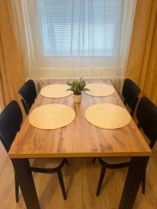 una mesa de madera con 4 sillas y una planta en ella en Apartmán vo vidieckom dome, en Malá Tŕňa