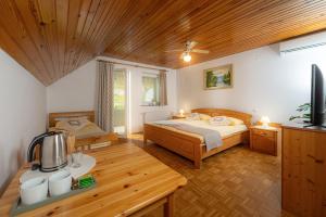 una camera con due letti e un tavolo con televisore di Rooms & Apartments Pr Matjon a Bled