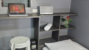 a room with a desk with a laptop and a stool at ERVORUTO HOSTEL 23 Makati in Manila