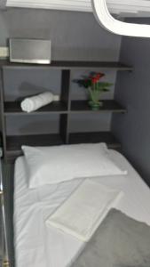 a bedroom with a white bed with a flower on it at ERVORUTO HOSTEL 23 Makati in Manila