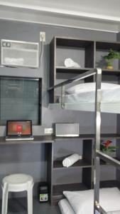 a room with bunk beds and a desk with a laptop at ERVORUTO HOSTEL 23 Makati in Manila