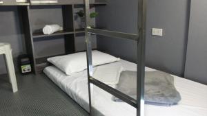 a bunk bed in a room with a ladder to a bunk bed at ERVORUTO HOSTEL 23 Makati in Manila