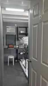 a door to a room with bunk beds and a desk at ERVORUTO HOSTEL 23 Makati in Manila