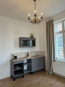 a kitchen with a desk and a chandelier at Toscana in Lübeck