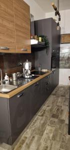 uma cozinha com armários cinzentos e uma bancada em Nico&Francy holiday em Iglesias