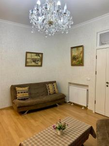 ein Wohnzimmer mit einem Sofa und einem Kronleuchter in der Unterkunft Best Location Renovated Home in Tbilisi City