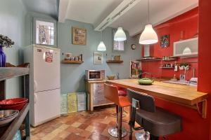 a kitchen with red and green walls and a wooden counter at Amiradou in Éguilles