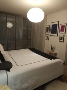 Un dormitorio con una gran cama blanca y una lámpara de araña. en DynastyConcept Luxury, en Risch-Rotkreuz