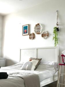 - une chambre dotée d'un lit blanc avec des plantes sur le mur dans l'établissement Modern 2 Bed, 2 Bath Flat in Central London Zone 1, à Londres