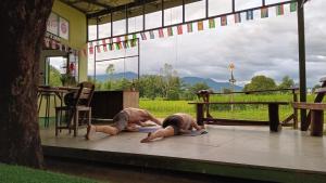 拜縣的住宿－Chill In Pai - ชิลล์ อิน ปาย，两个人躺在大楼的地板上