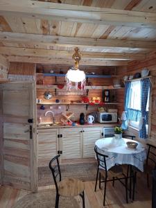 una cocina con mesa en una cabaña en Magia Krutyni Domek nr2, en Ukta