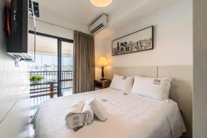 a bedroom with a large bed with a balcony at Rosemari's Apartments SJ Urban Chic in Sao Paulo