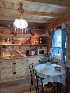 cocina con mesa y lámpara de araña en Magia Krutyni Domek nr2, en Ukta