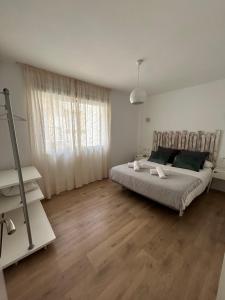 1 dormitorio blanco con 1 cama y suelo de madera en Apartamento Soho centro malaga, en Málaga