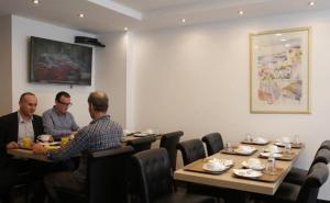 three men sitting at tables in a restaurant at Luxor Bastille Hotel in Paris