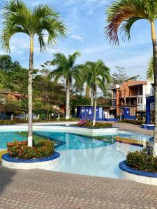 uma piscina com palmeiras num resort em Casa Vacacional Ciudadela Sol em San Jerónimo
