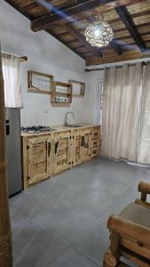 a kitchen with wooden cabinets and a sink at Mano a Mano Eco Hostal in Las Peñitas