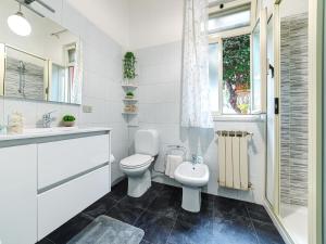 a white bathroom with a toilet and a sink at Sea Shell in Riposto