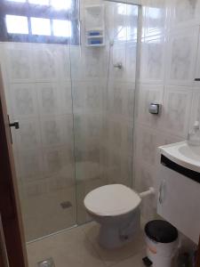 ein Badezimmer mit Dusche, Toilette und Waschbecken in der Unterkunft Casa sobreposta alta em Boiçucanga - São Sebastião in São Sebastião