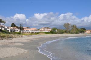 une plage de sable avec des maisons en arrière-plan dans l'établissement Studio en bord de mer sur Costa Serena N54, à Linguizzetta