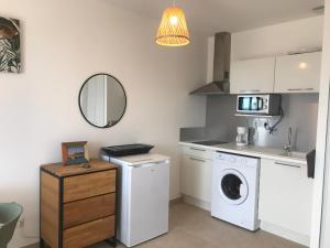 une cuisine avec un lave-linge, un sèche-linge et un miroir dans l'établissement Studio en bord de mer sur Costa Serena N54, à Linguizzetta