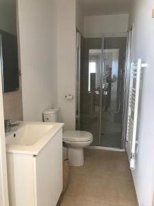 a white bathroom with a toilet and a shower at Studio en bord de mer sur Costa Serena N54 in Linguizzetta