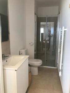 une salle de bain blanche avec toilettes et douche dans l'établissement Studio en bord de mer sur Costa Serena N54, à Linguizzetta