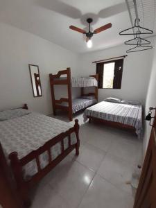 ein Schlafzimmer mit zwei Betten und einem Fenster in der Unterkunft Casa sobreposta alta em Boiçucanga - São Sebastião in São Sebastião