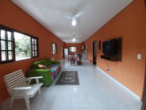 ein Wohnzimmer mit einem grünen Sofa und einem Fernseher in der Unterkunft Casa sobreposta alta em Boiçucanga - São Sebastião in São Sebastião + 33 Fotos