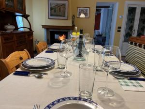 stół z kieliszkami i talerzami na stole w obiekcie Appartamento Cechouse a Traona w mieście Traona