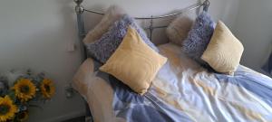 a bed with pillows on it with flowers on it at 3 bed house in Gloucester near to city centre 