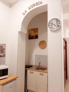 uma cozinha com um lavatório e um relógio na parede em LA MURGIA casa vacanze B&B em Grumo Appula