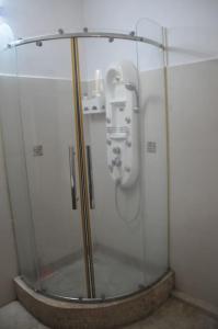 una ducha de cristal con lavabo en una habitación en * La Petite Villa * Golf de Mont Choisi *, en Mont Choisy