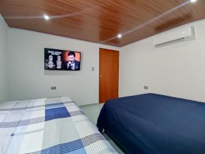 a bedroom with a bed and a tv on the wall at Acogedor Apartamento Alpha in Cartagena de Indias