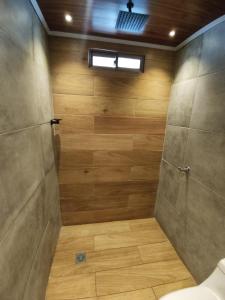 a bathroom with a shower with a toilet and wooden walls at Acogedor Apartamento Alpha in Cartagena de Indias