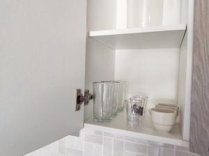 a kitchen with a shelf with glass vases on it at Acogedor Apartamento Alpha in Cartagena de Indias