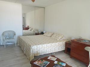 a bedroom with two beds and a dresser and a mirror at Just in paradise in Baie Nettle