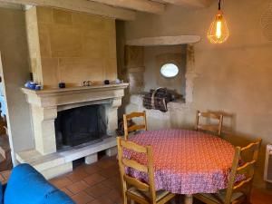 uma sala de jantar com uma mesa e uma lareira em Gite Introvigne Sarlat em Sarlat-la-Canéda