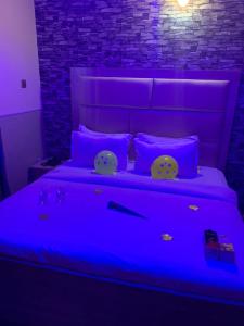 a bedroom with a bed with a blue light at FORTUNE PEARL HOTEL in Lagos