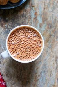 een kopje koffie zittend op een houten tafel bij Hotel the pacific Chakala in Mumbai