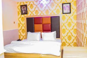 sypialnia z łóżkiem z pomarańczową i żółtą ścianą w obiekcie FORTUNE PEARL HOTEL w mieście Lagos