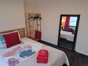 a bedroom with a bed with a red suitcase on it at Nina's Cozy Lodge in Wigan
