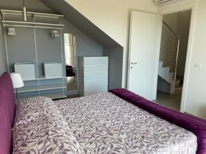 a bedroom with a large bed with purple sheets at Polinesia 12 in Lido delle Nazioni